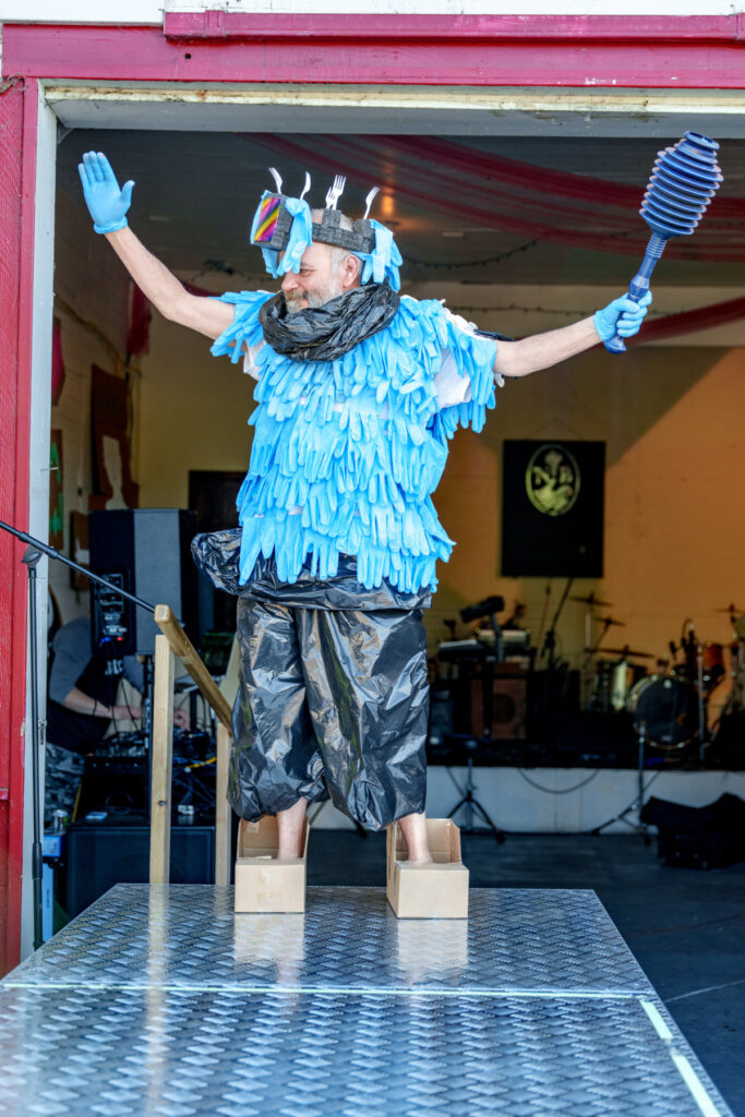 Ben Ballou proves that shoes do indeed make the outfit -- especially when paired with rubber gloves and a toilet plunger -- at Heart of Cartm's 2023 Trashion Show, held at Nehalem Bay Winery. Photo by: Broken Banjo Photography